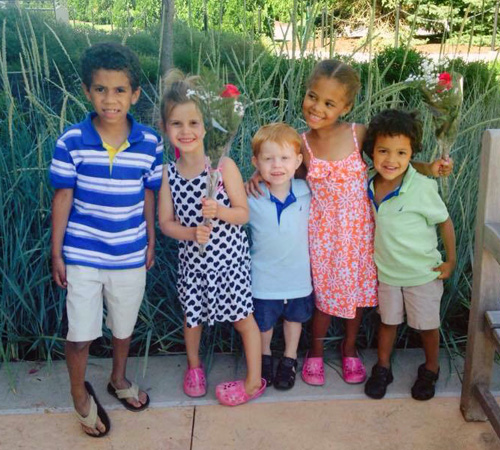 A group of adopted or fostered children happily smiling as a group.